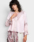 Woman wearing a pink lace blouse with a white background