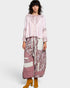 Woman wearing a patterned outfit with a long dress and blouse on a white background