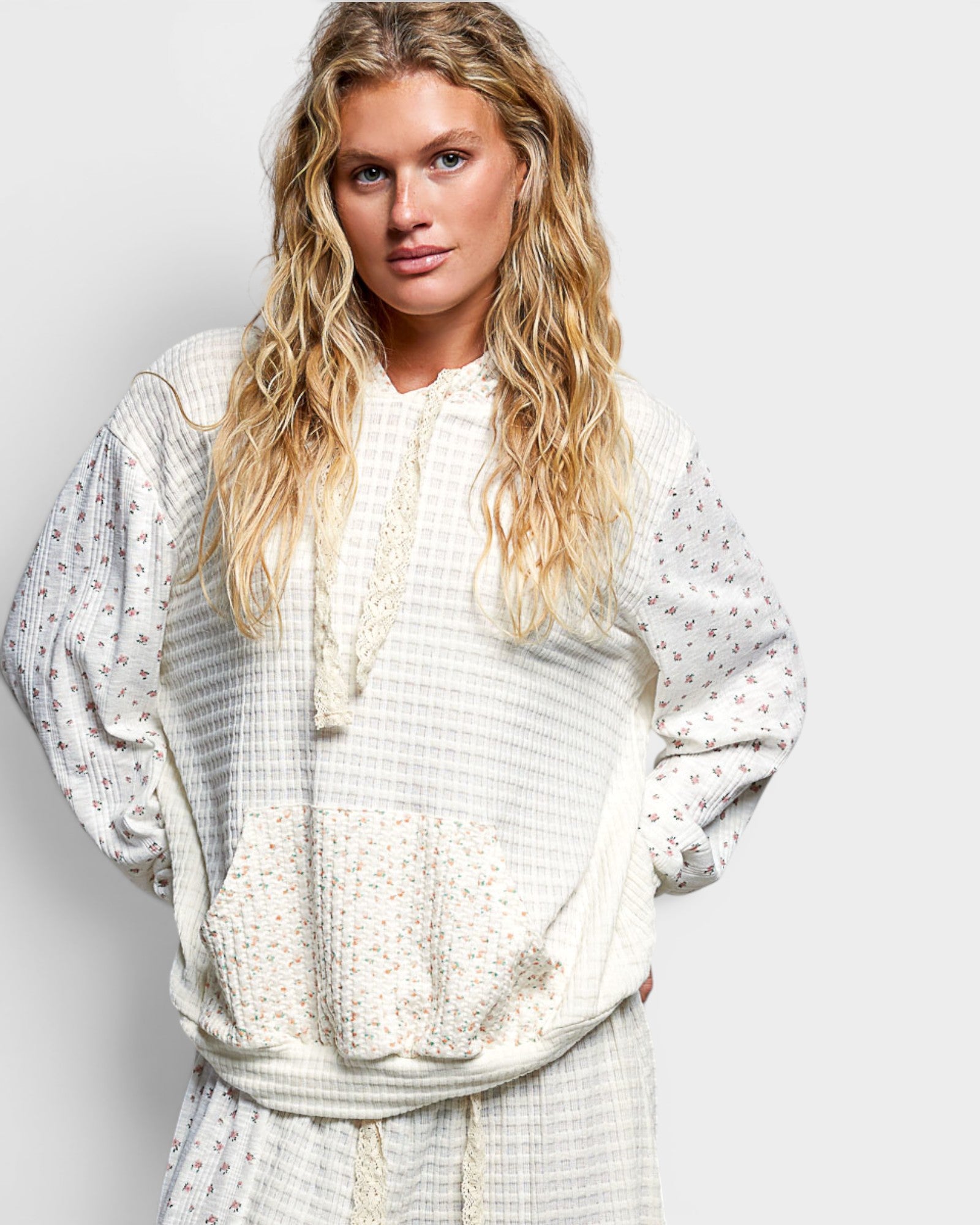 Woman wearing a white patterned outfit against a plain background