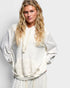 Woman wearing a white patterned outfit against a plain background