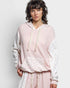 Person wearing a pink textured hoodie and pants on a light gray background