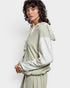 Woman wearing a light green and white outfit with a plain background