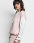 Person wearing a light pink and white outfit with a textured pattern on a plain background