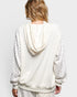 Person wearing a white textured hoodie with floral patterns on a plain background