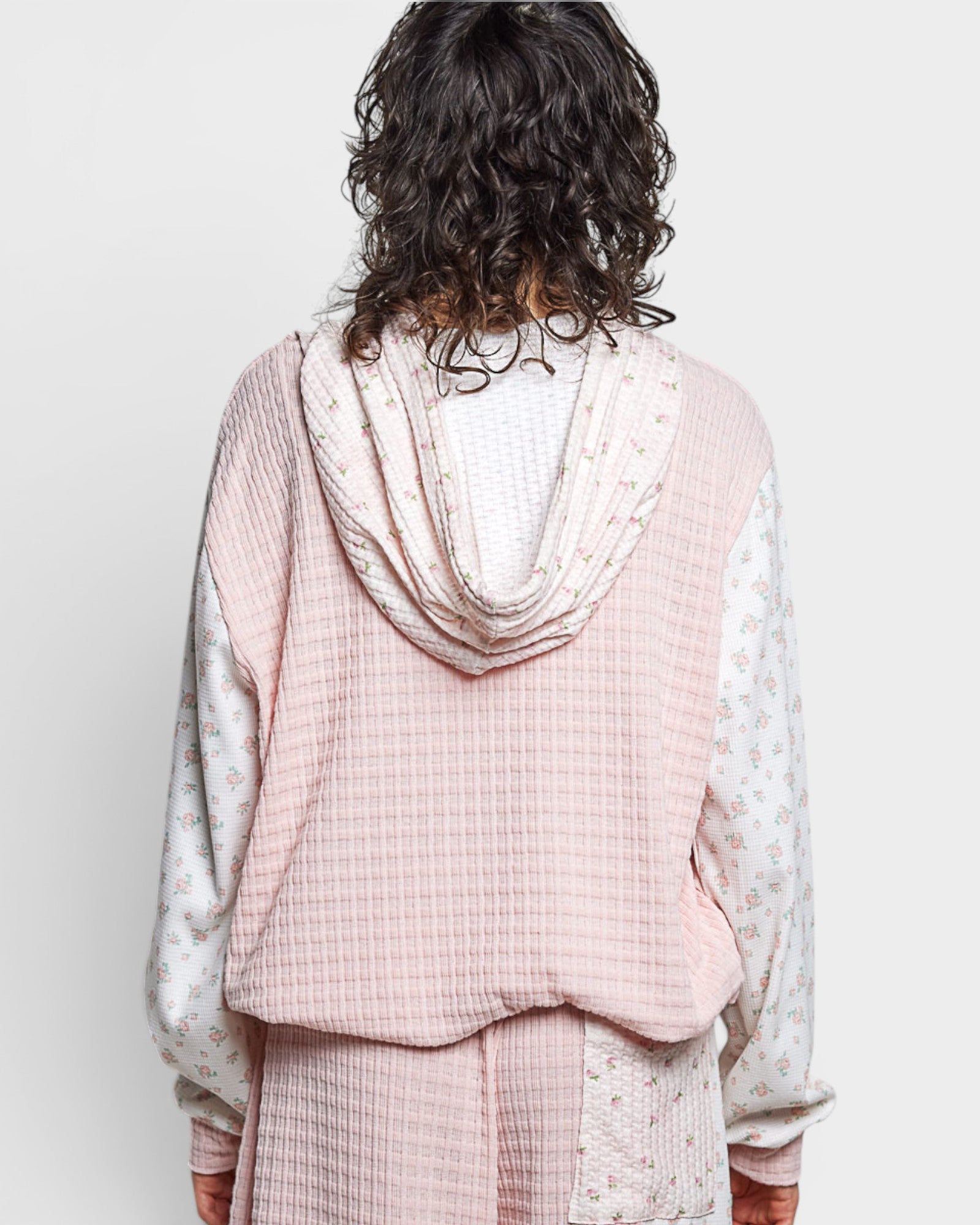 Person wearing a pink checkered outfit with a white background