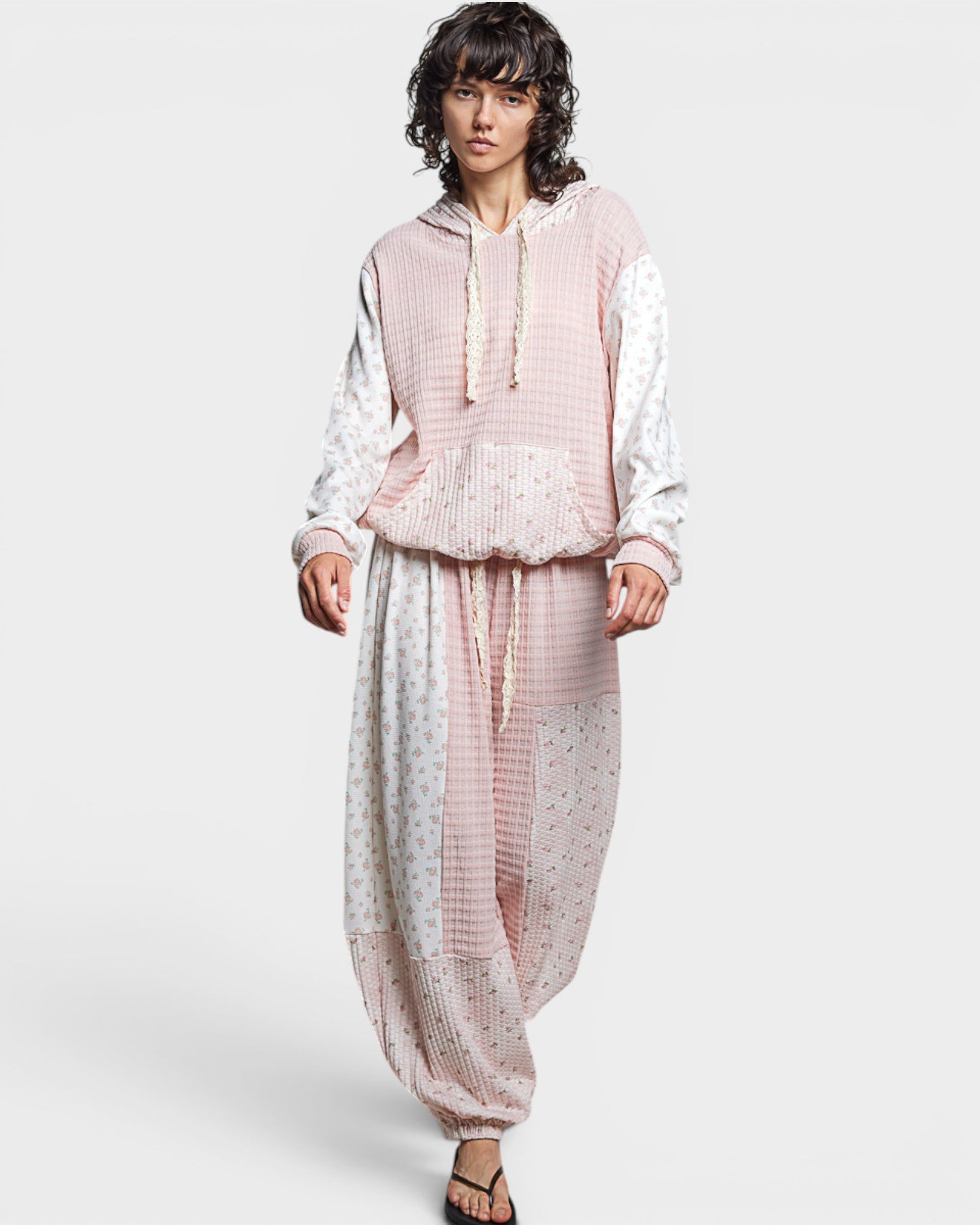 Woman wearing a pink and white outfit with a pattern on a white background