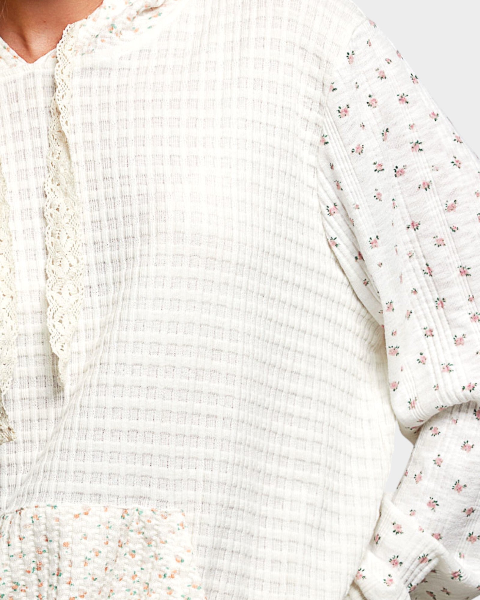 Close-up of a white textured fabric with floral patterns on a light background