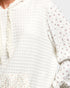 Close-up of a white textured fabric with floral patterns on a light background