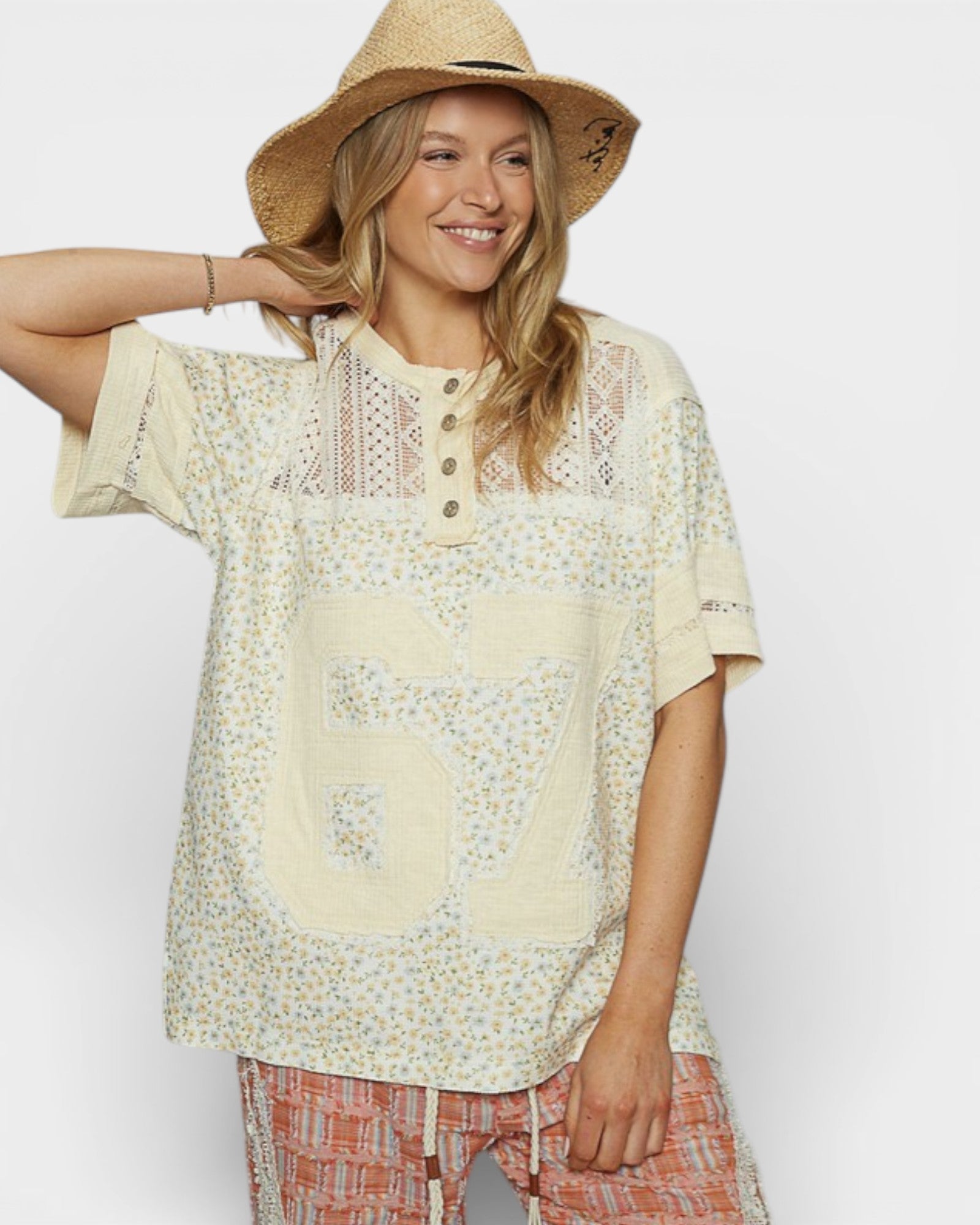 Woman wearing a floral blouse with a large number 67 on a plain background