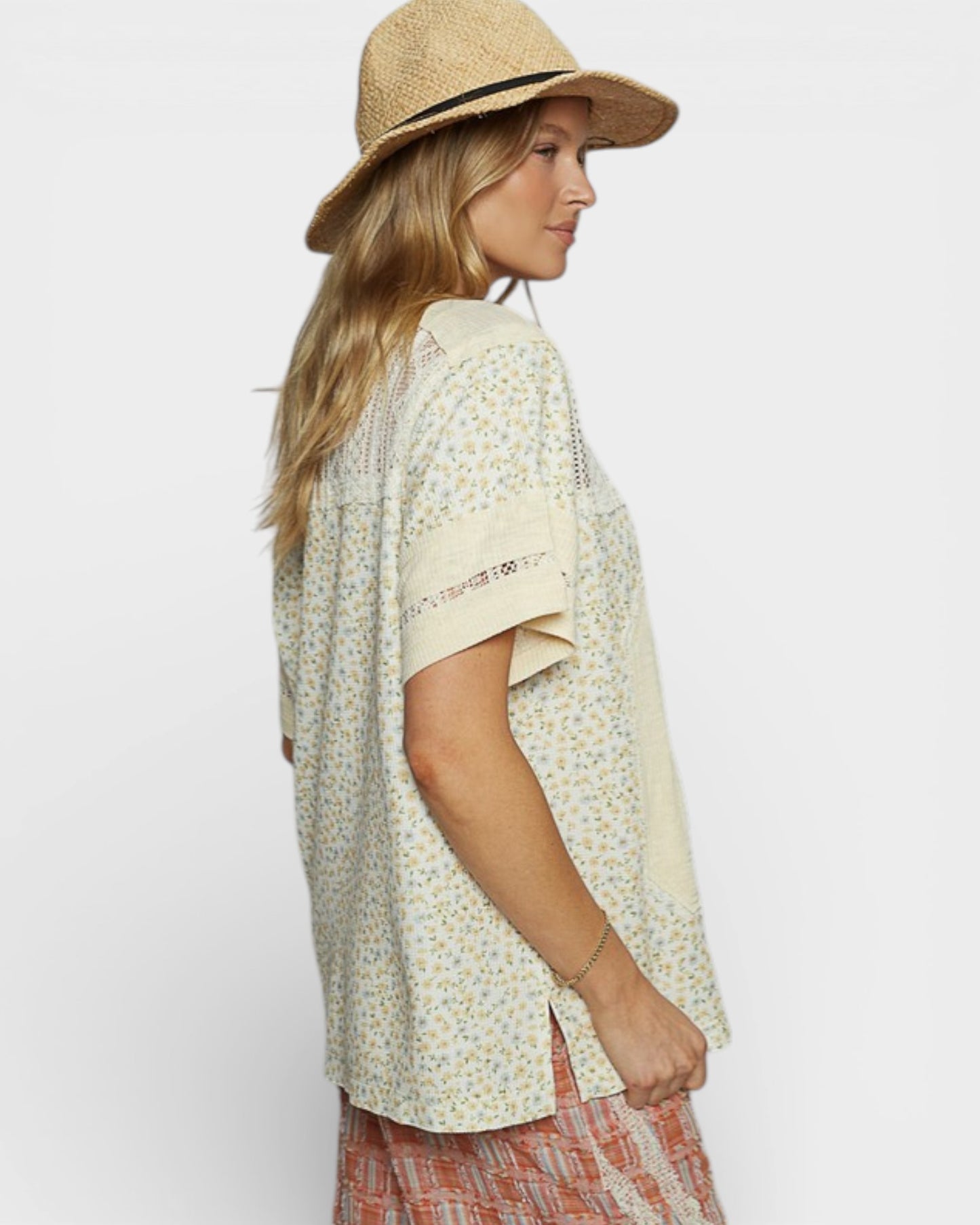 Woman wearing a floral blouse and straw hat on a white background