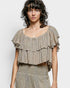 Woman wearing a ruffled top with a plain background
