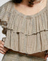 Close-up of a textured, ruffled top with a neutral color palette.