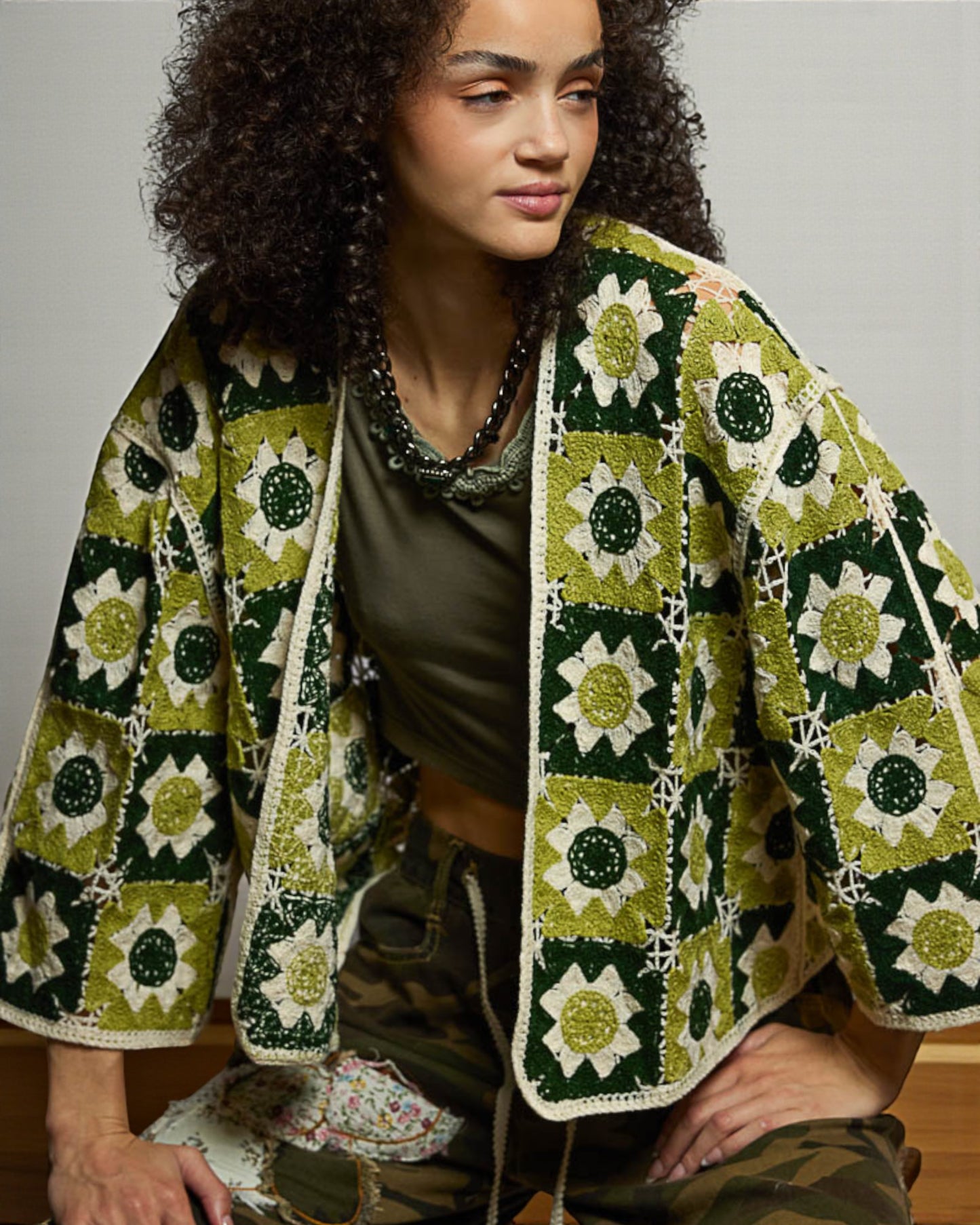 Woman wearing a green and white patterned jacket with a neutral background