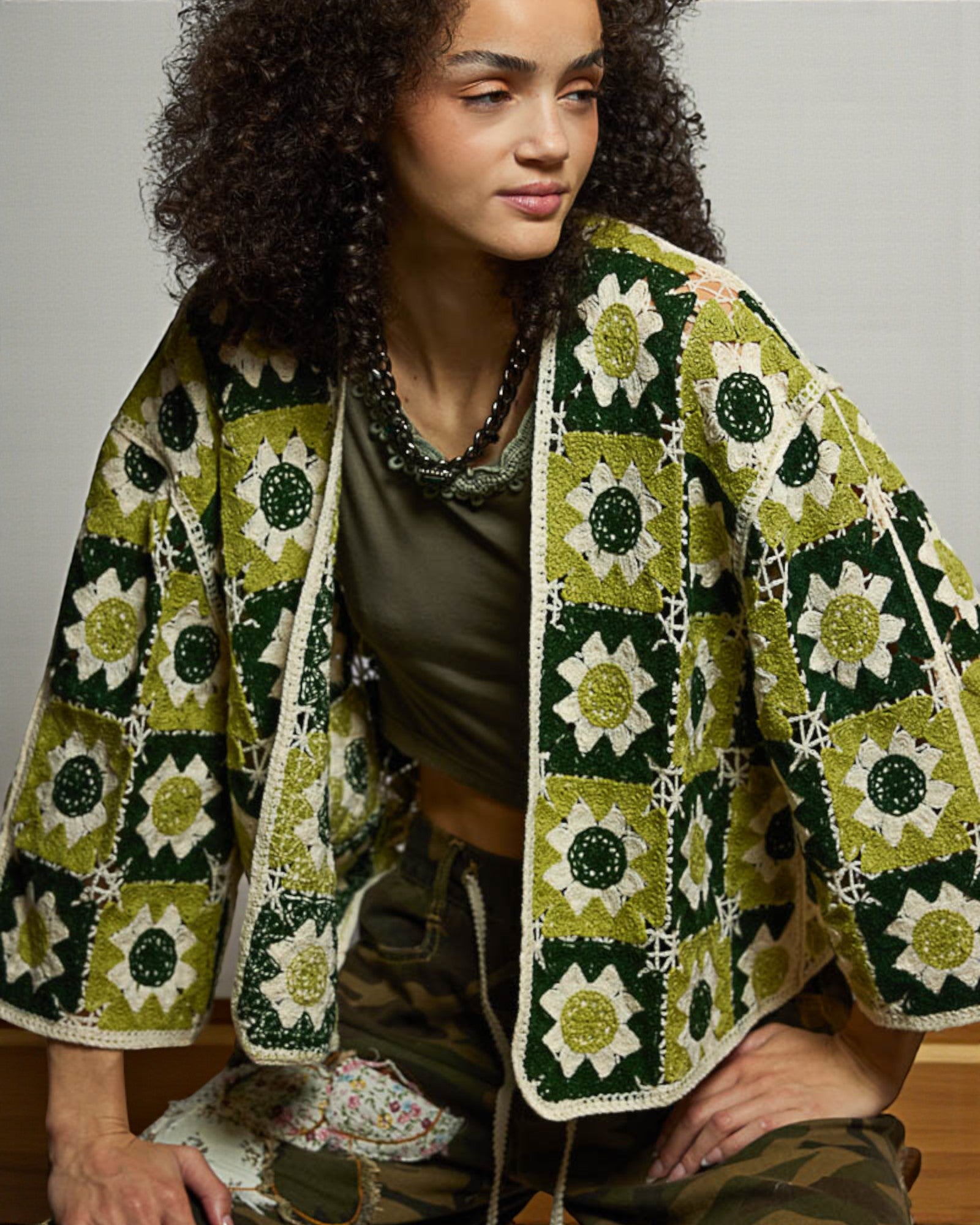Woman wearing a green and white patterned jacket with a neutral background