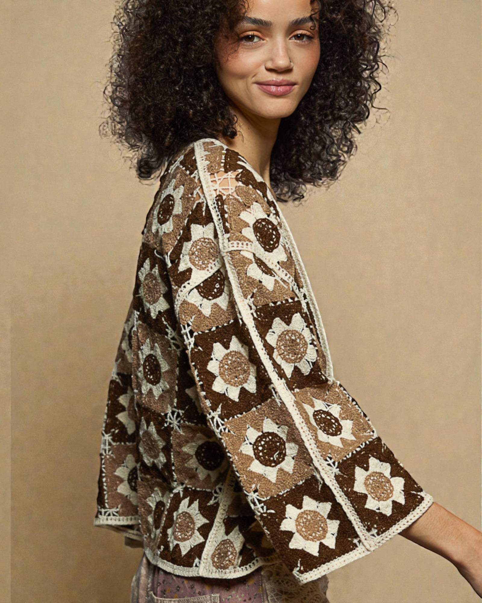 Woman wearing a brown and beige patterned kimono against a beige background