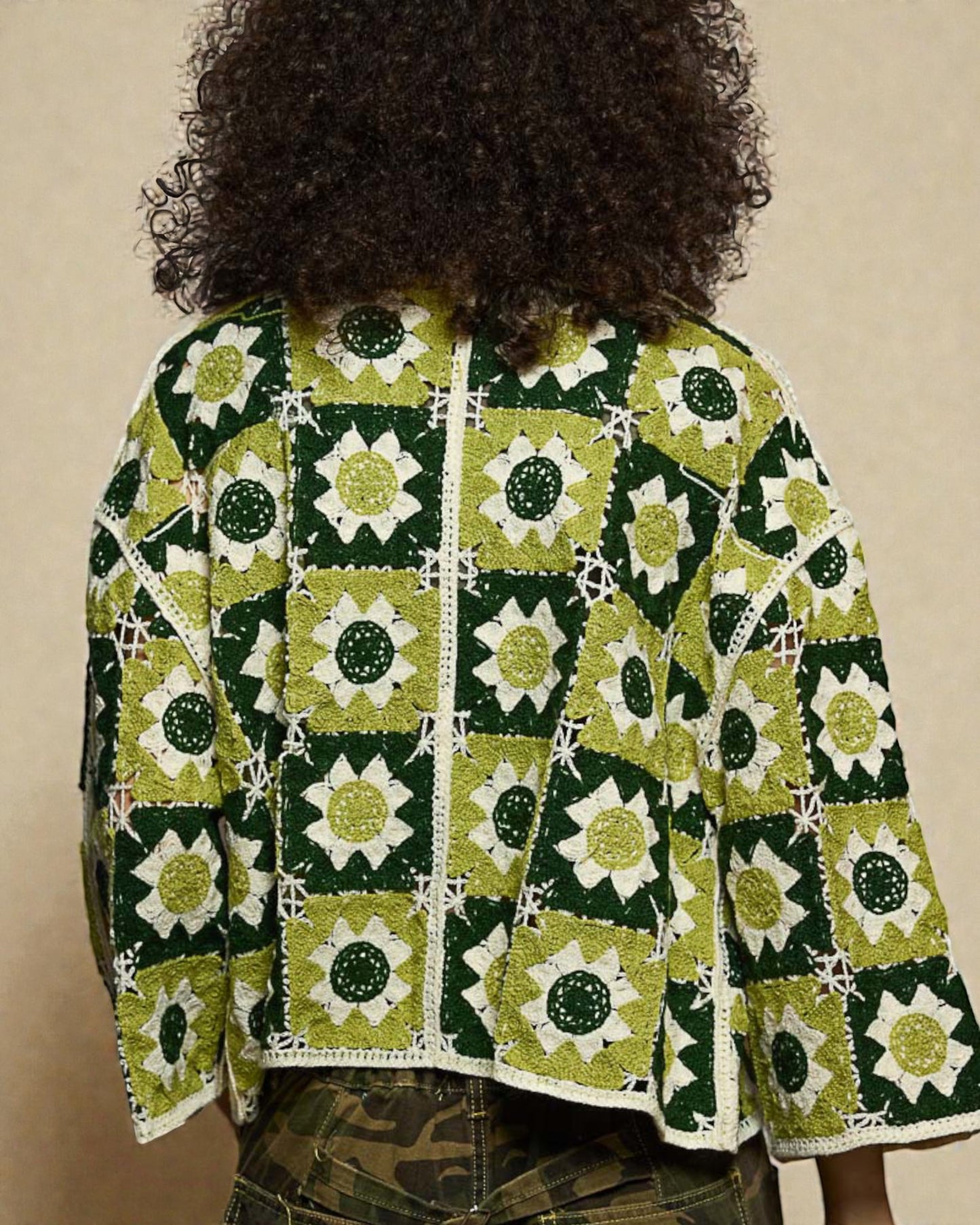 Person wearing a green and white patterned jacket with a beige background