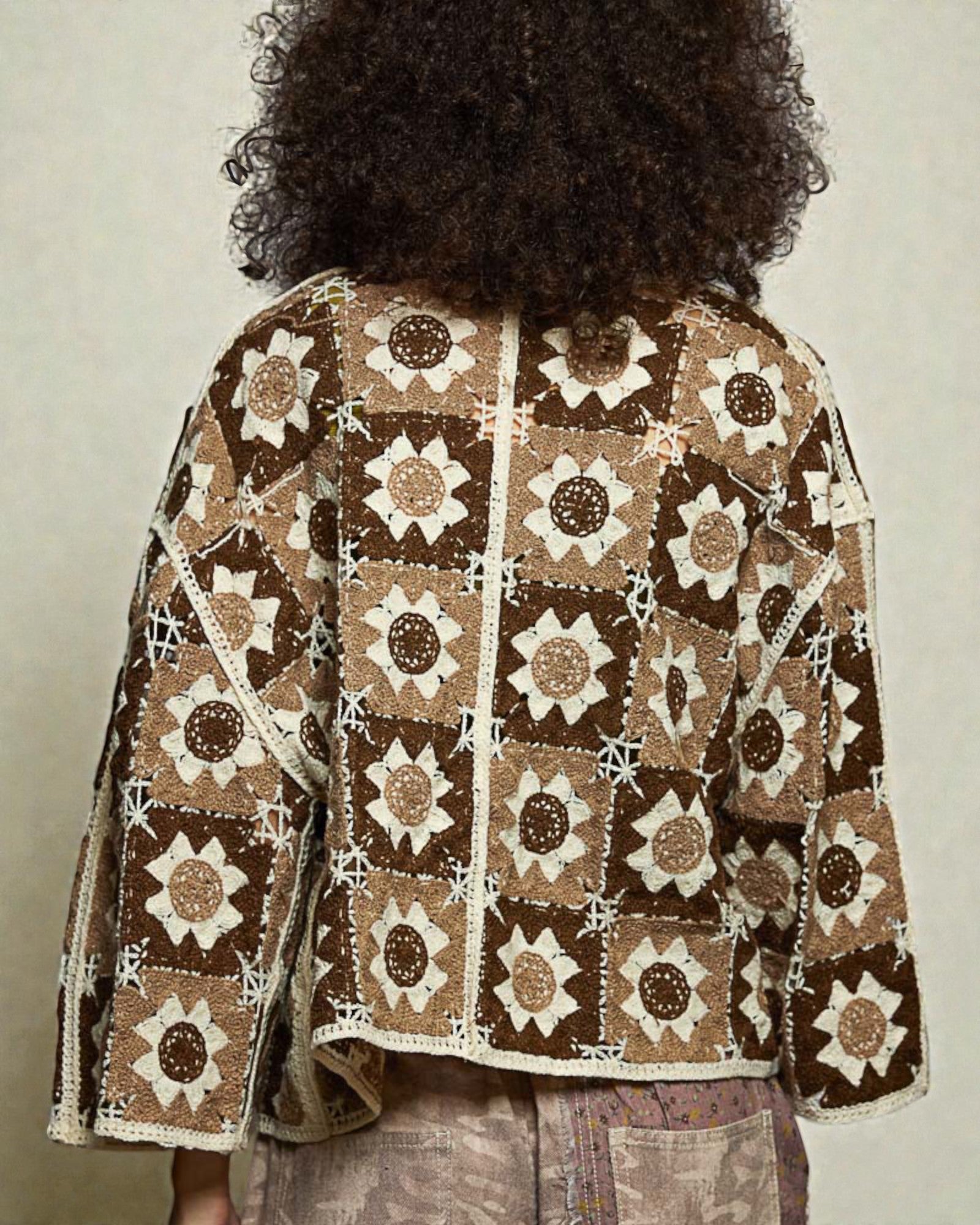 Person wearing a patterned jacket with a neutral background