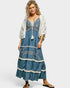 Woman wearing a blue embroidered dress with a white lace cardigan on a white background