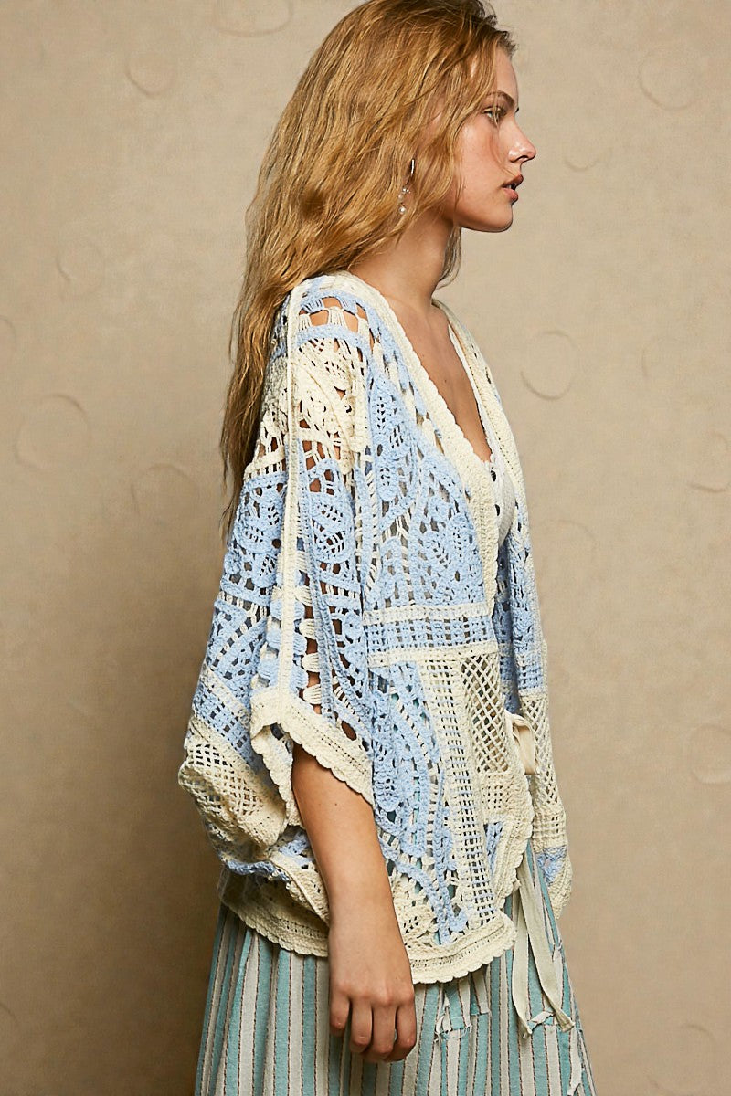Woman wearing a crochet cardigan with a beige background
