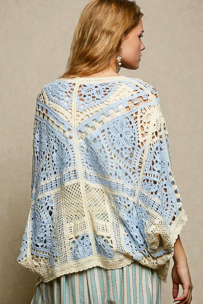 Woman wearing a crocheted shawl with a geometric pattern on a beige background