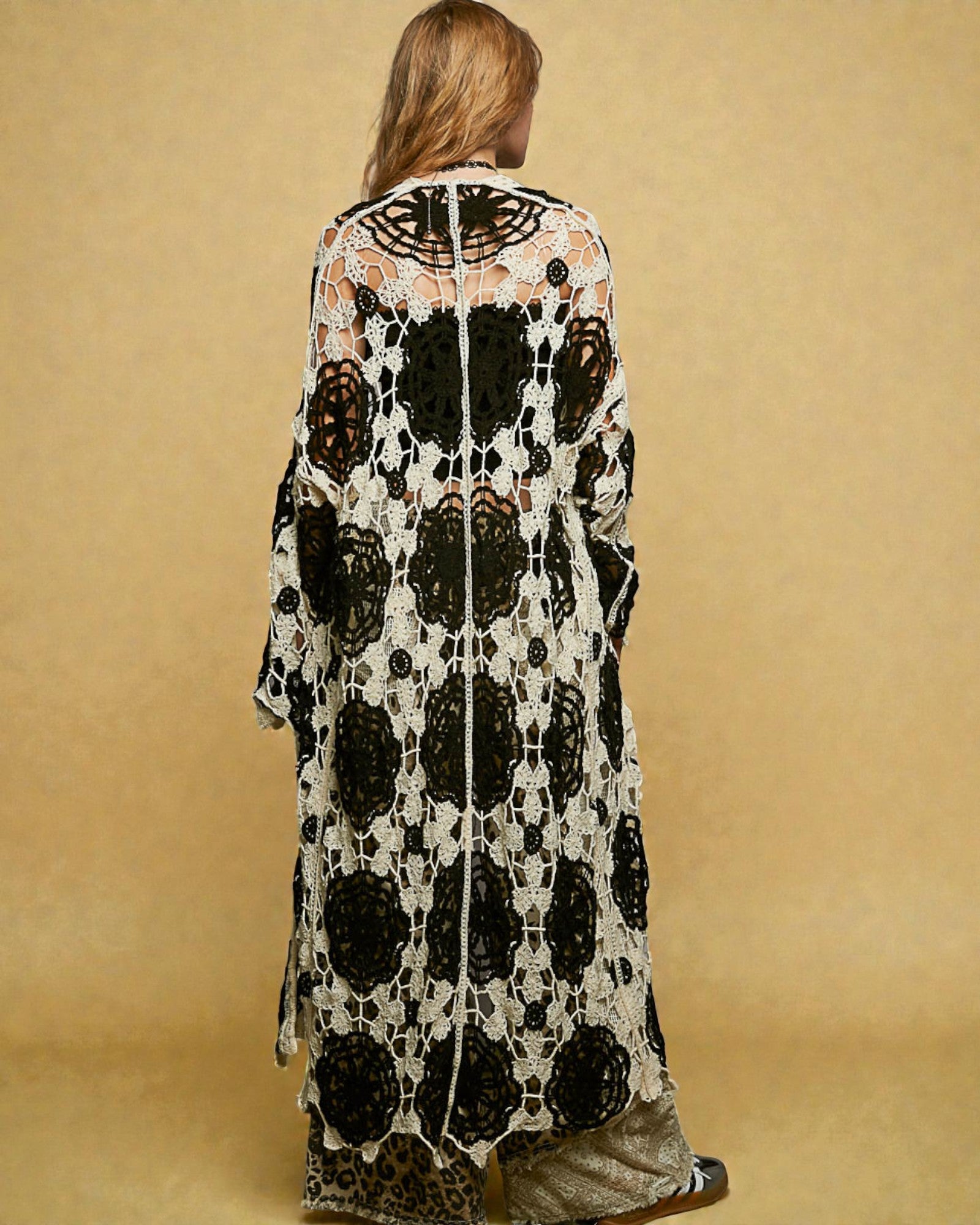Woman wearing a black and white patterned dress against a beige background