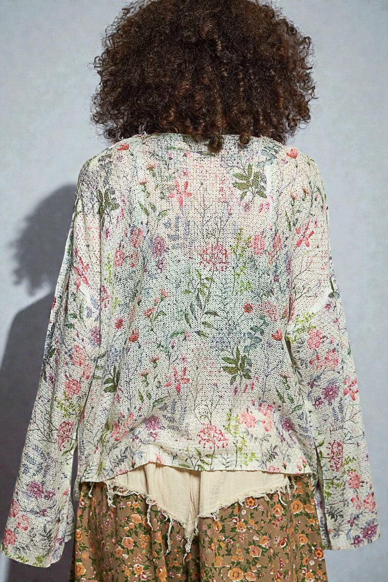 Person wearing a floral blouse with a plain background