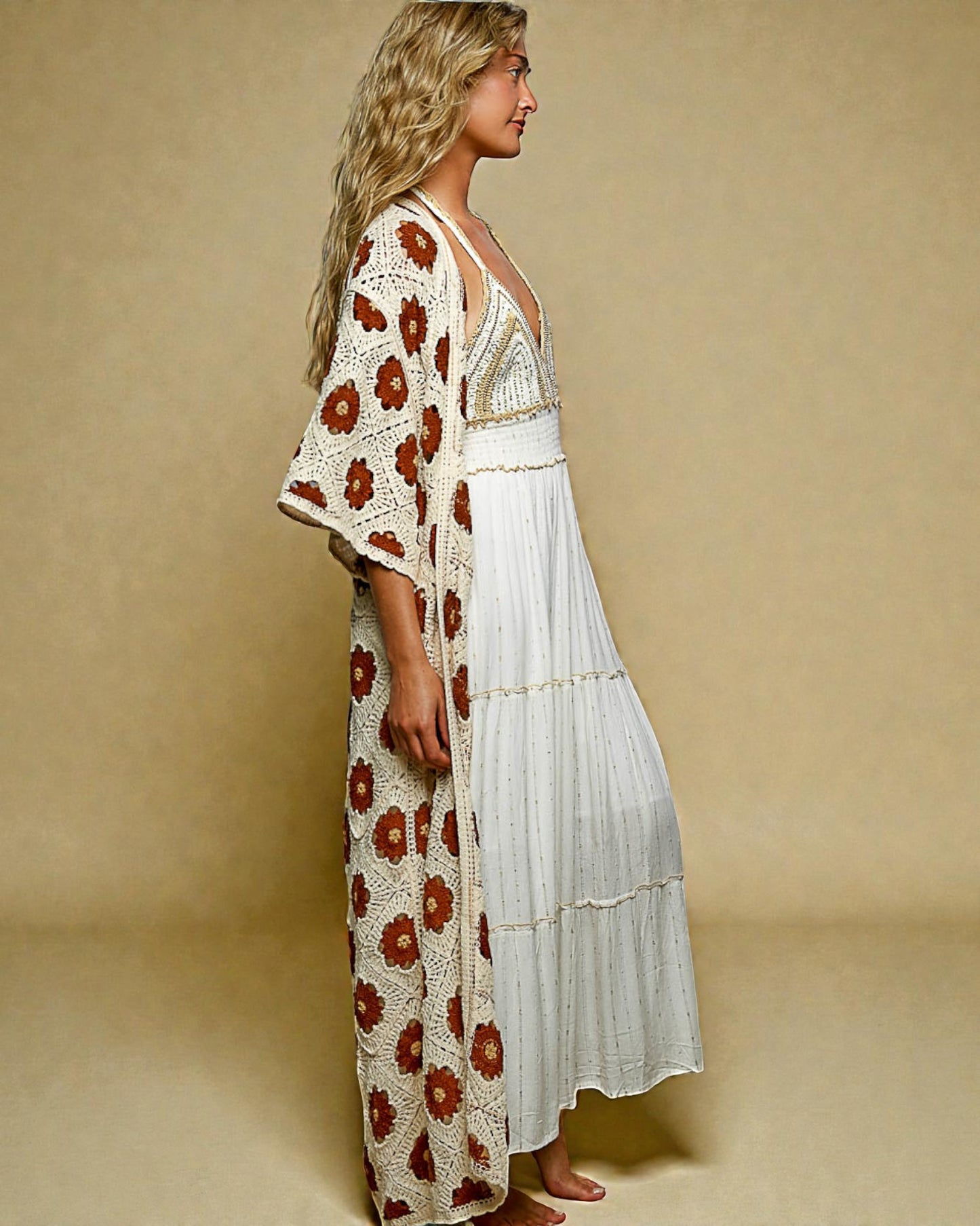 Woman wearing a floral kimono over a white dress on a beige background