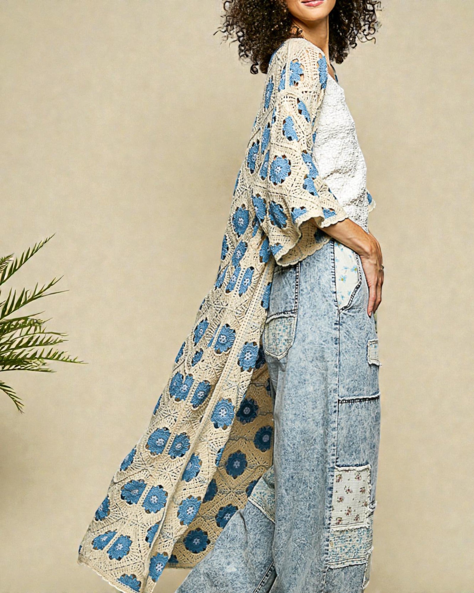 Woman wearing a blue floral kimono-style garment against a beige background