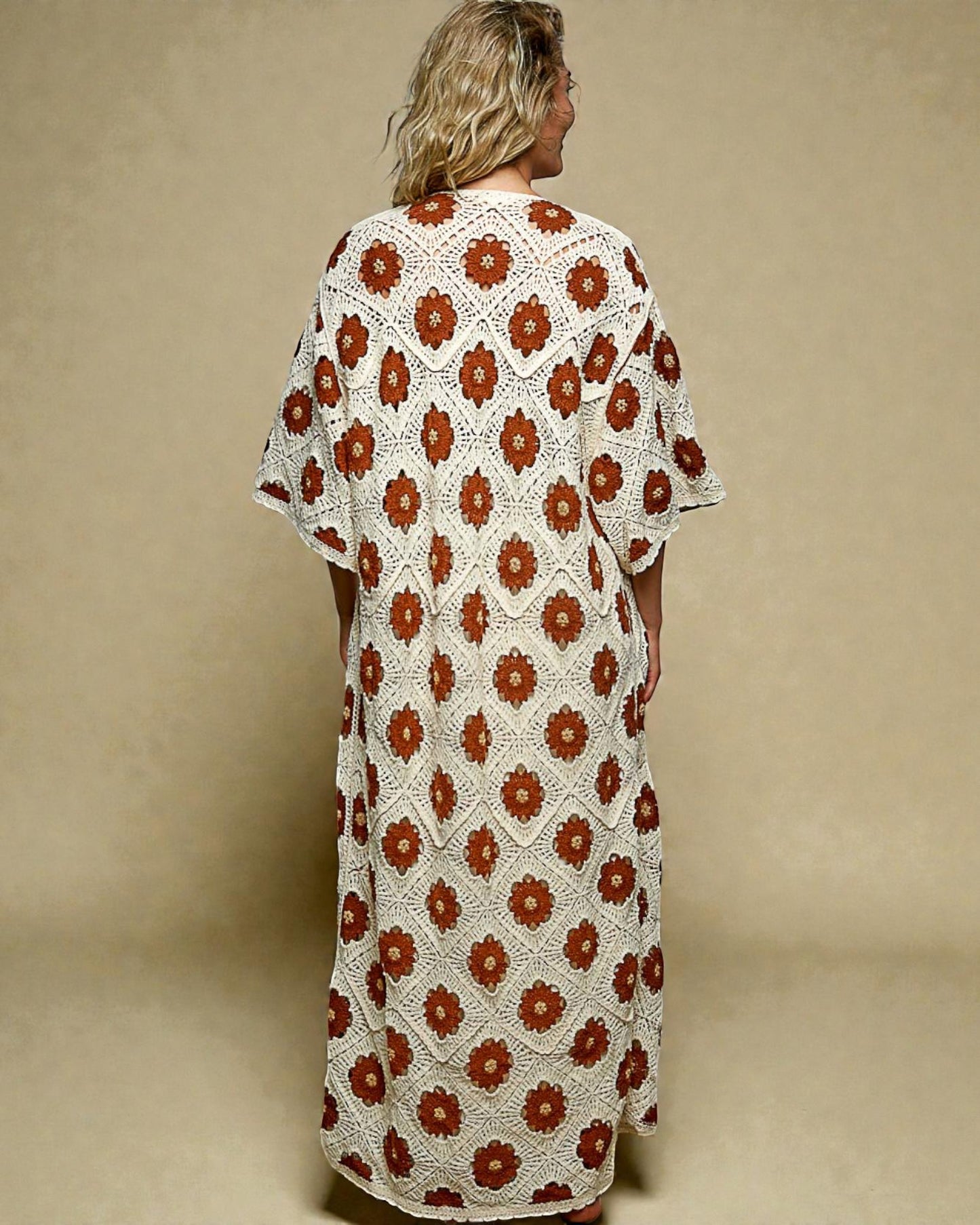 Woman wearing a long, patterned dress with a beige background