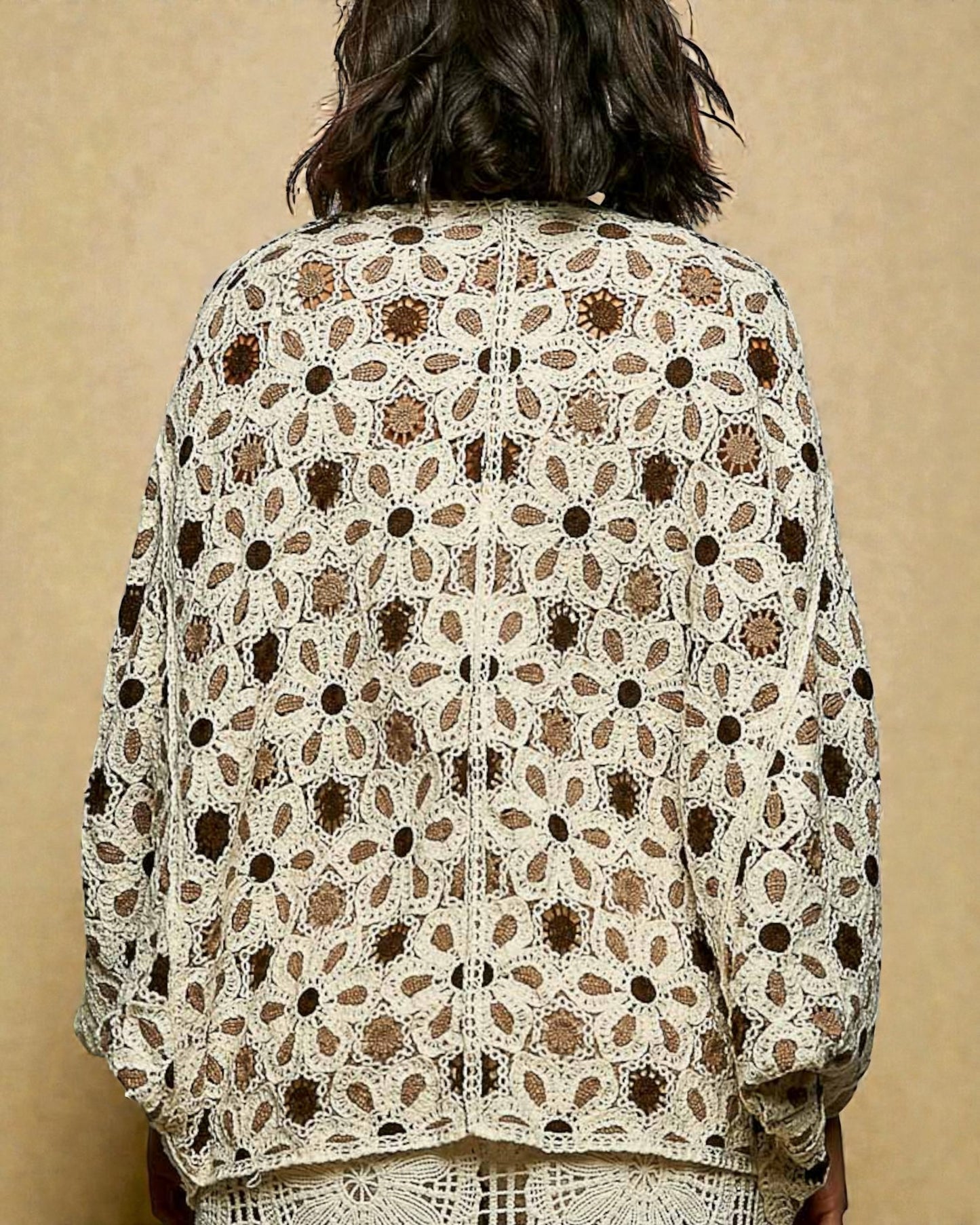 Person wearing a patterned jacket against a beige background