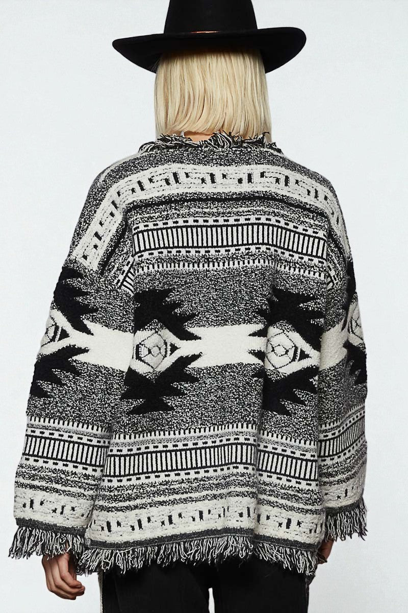 Person wearing a patterned poncho with a plain background