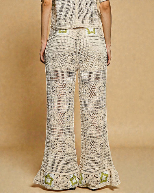 Person wearing a beige crochet outfit with green accents on a beige background