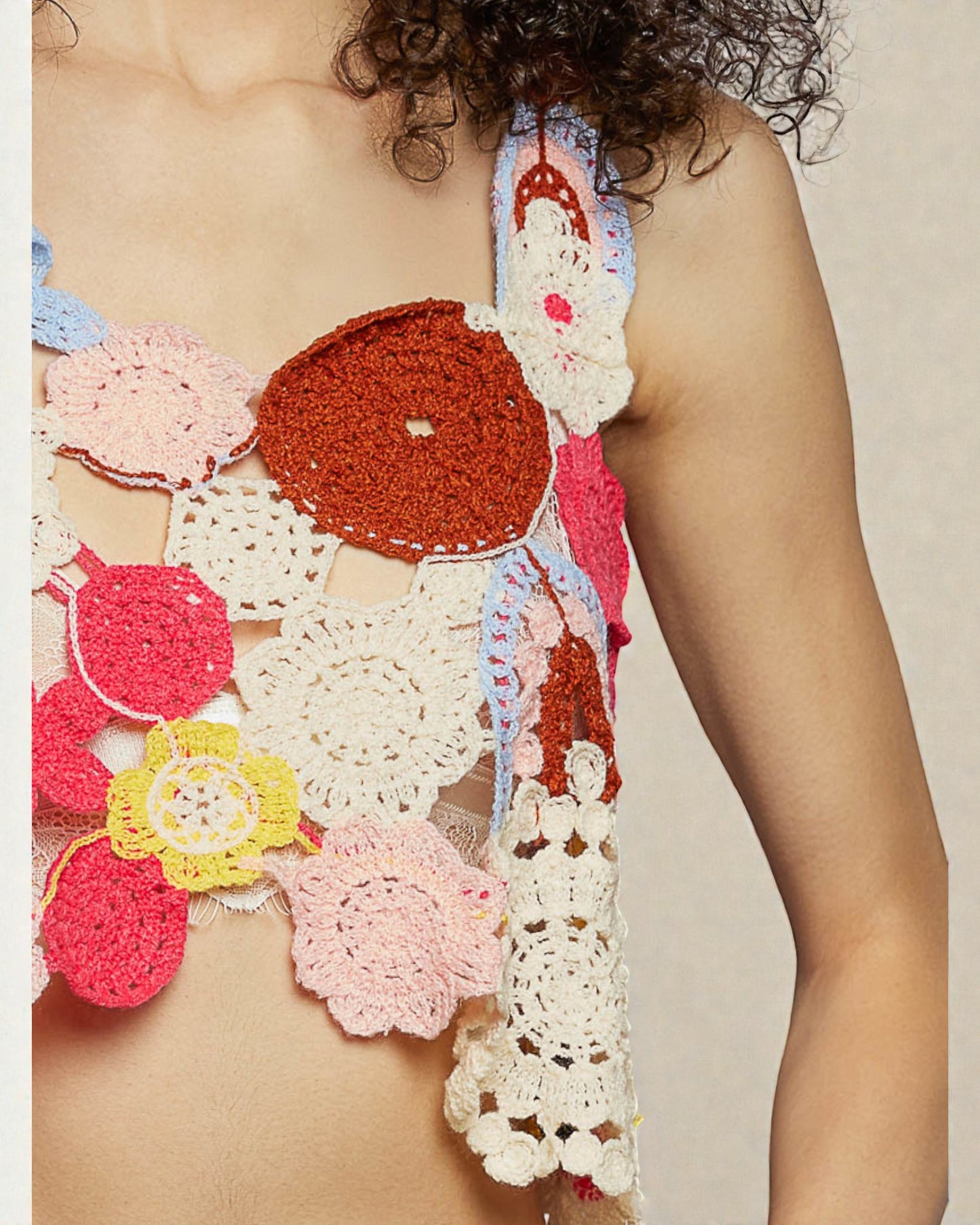 Colorful crochet top with floral patterns on a neutral background