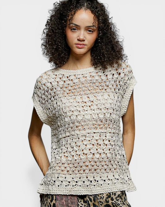 Woman wearing a beige crochet top on a white background