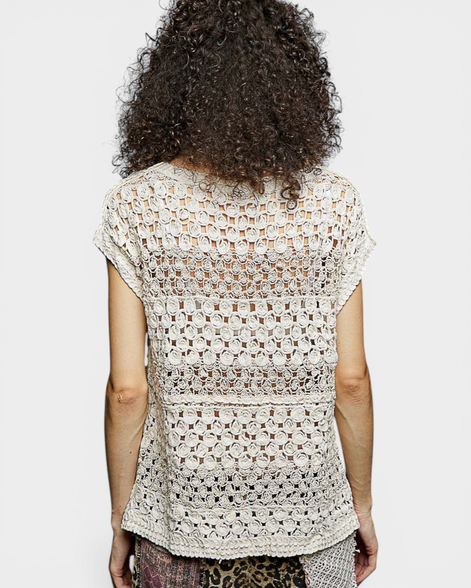 Person wearing a patterned top with a plain background