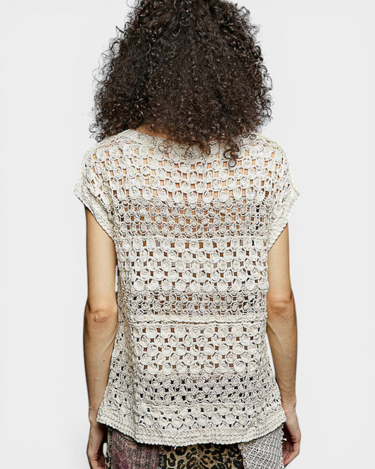 Person wearing a patterned top with a plain background