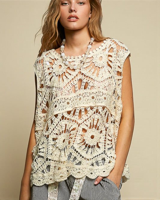 Woman wearing a sleeveless crochet top against a beige background