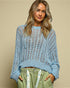 Woman wearing a light blue knitted sweater against a beige background