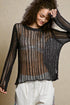 Woman wearing a sheer black and brown patterned top against a beige background