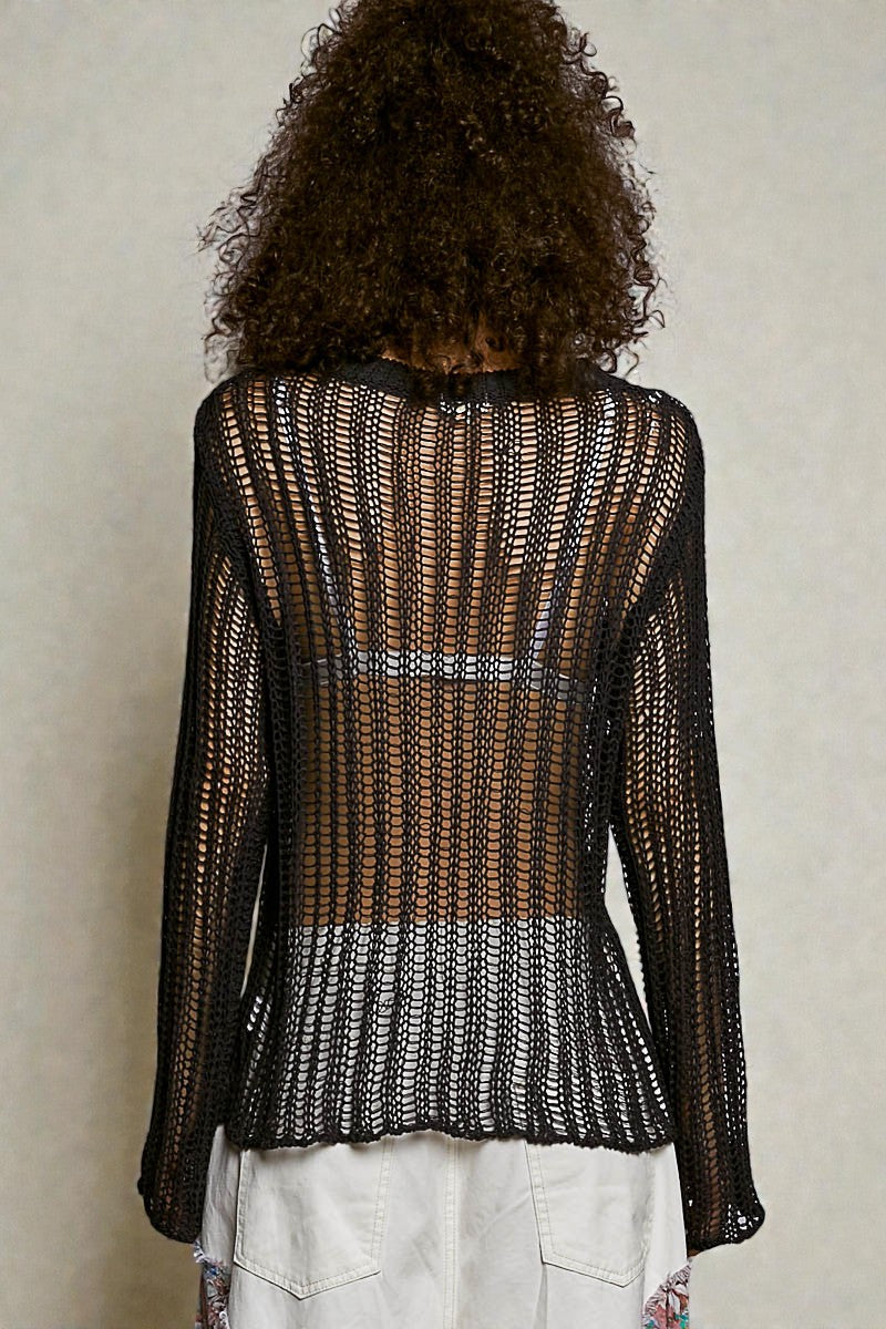 Person wearing a black and white patterned top with a neutral background