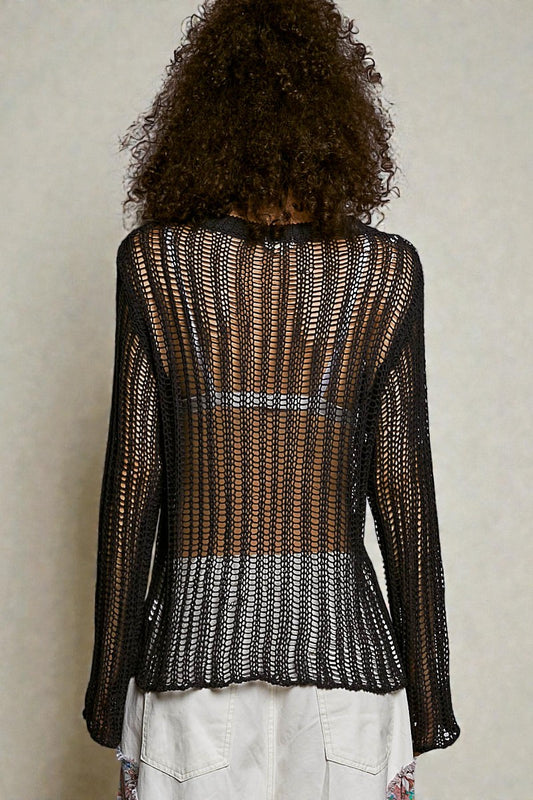 Person wearing a black and white patterned top with a neutral background