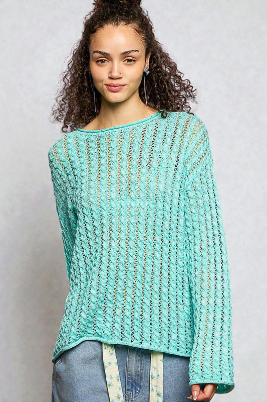 Woman wearing a light blue knitted sweater against a plain background