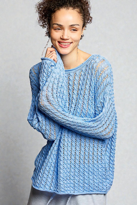 Woman wearing a blue knitted sweater against a gray background