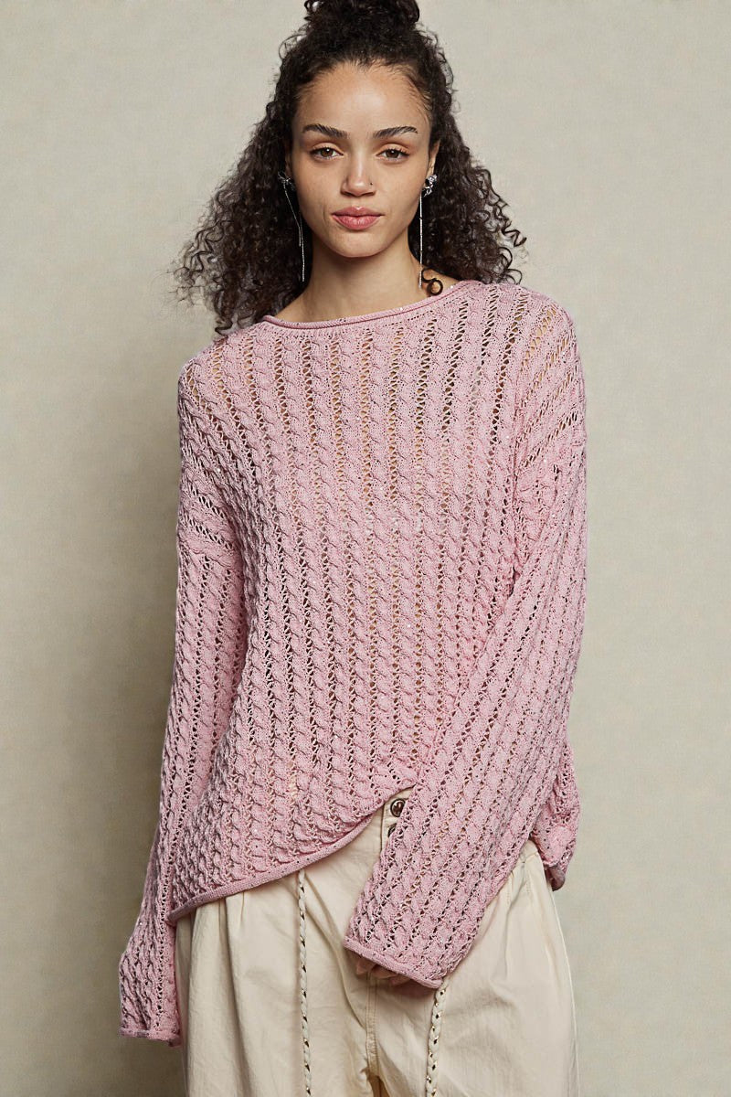 Woman wearing a pink knitted sweater against a plain background
