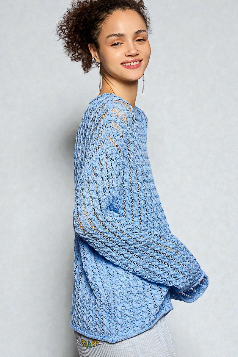 Woman wearing a light blue knitted sweater against a plain background