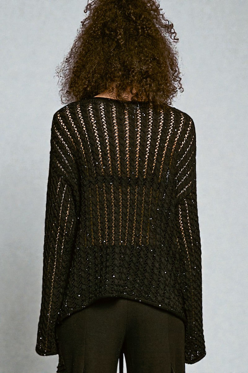 Person wearing a dark brown textured sweater against a plain background