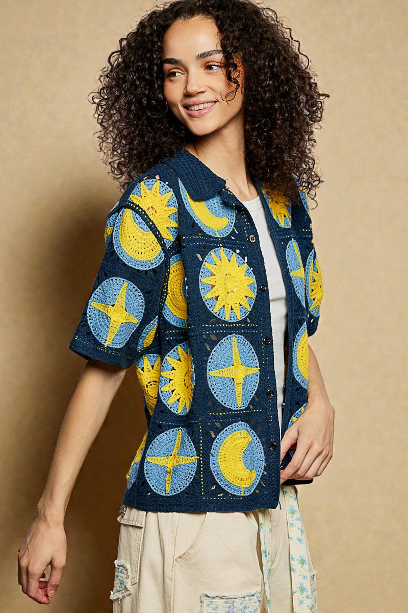Woman wearing a colorful jacket with sun and moon patterns on a beige background