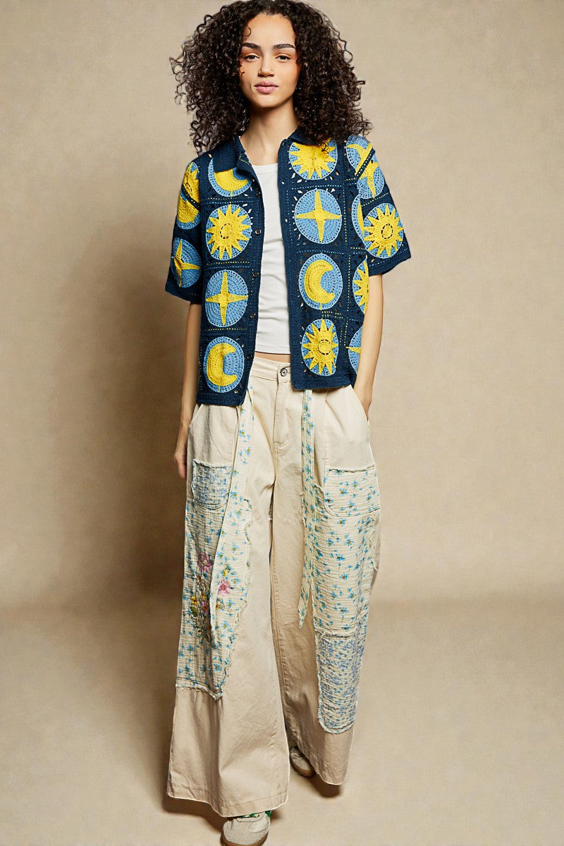 Woman wearing a colorful embroidered jacket with a beige background