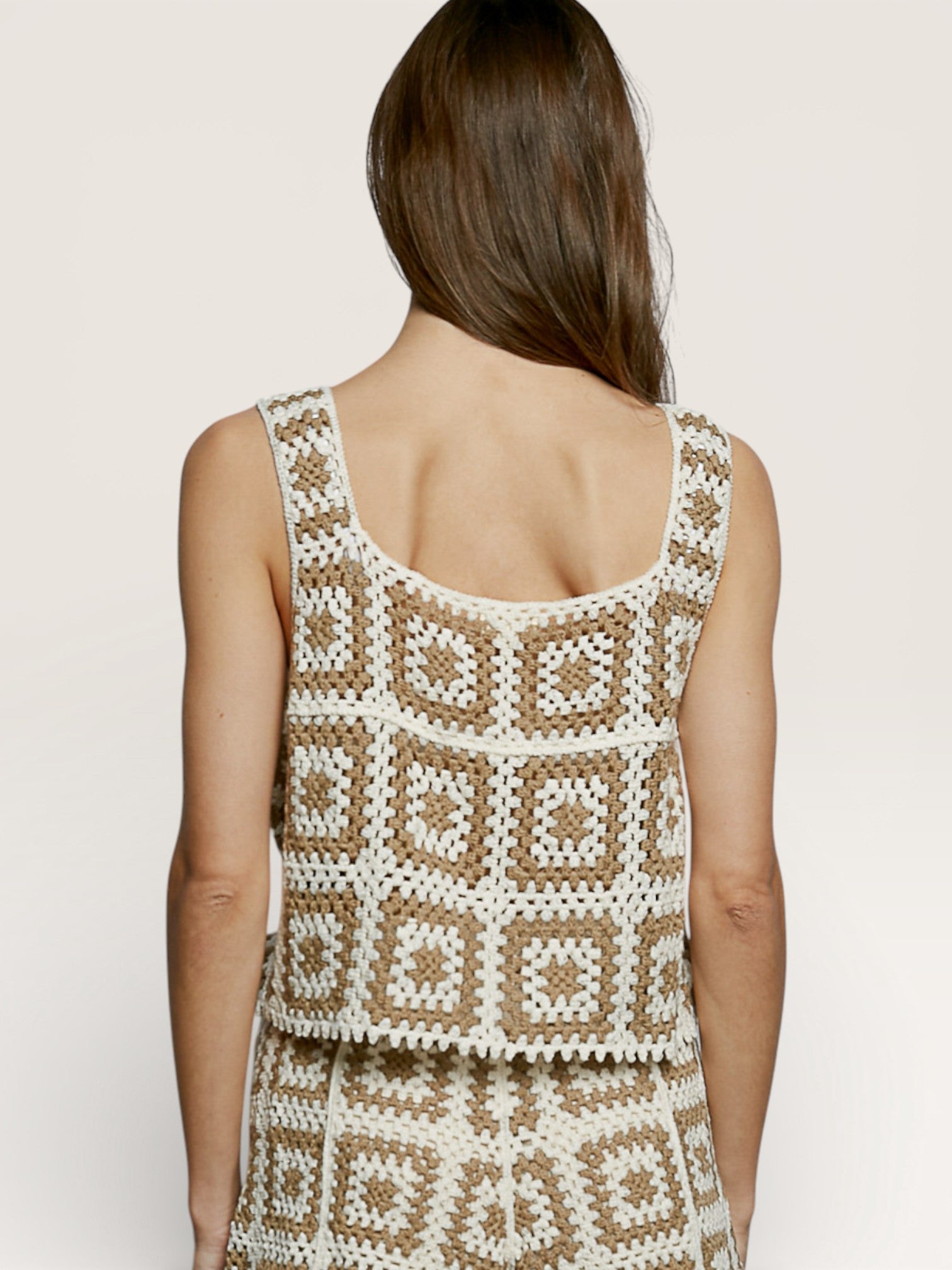 Woman wearing a patterned dress with a neutral background