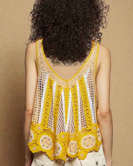 Person wearing a yellow crochet tank top against a beige background